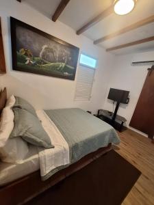 a bedroom with a bed with a painting on the wall at Villa Coral in Hucares