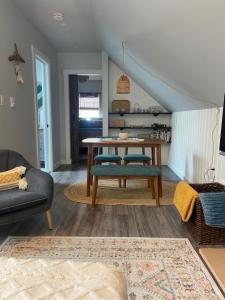 uma sala de estar com uma mesa e um sofá em Seaside Perch em Sooke