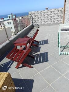 a red bench sitting on top of a roof at Malak House in Imsouane