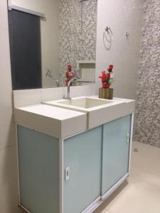 a bathroom with a sink and a mirror at HOSTEL D´ SALLES (PRÓXIMO AO AEROPORTO) in Palmas