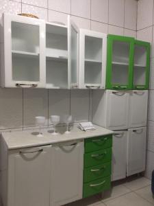 uma cozinha com armários verdes e brancos e um frigorífico em HOSTEL D´ SALLES (PRÓXIMO AO AEROPORTO) em Palmas