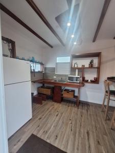 a kitchen with a wooden table and a refrigerator at Villa Coral in Hucares