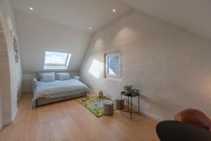 Schlafzimmer im Dachgeschoss mit einem Bett und einem Teppich in der Unterkunft Villa Veldzicht in Kortemark