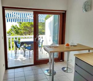a kitchen with an open door to a patio with a table at Apartments Secret Beach in Mimice