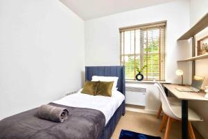 a bedroom with a bed and a desk with a computer at Next to Headingley Stadium - Perfect for Families & Work - Contact us for Better Offers! in Headingley