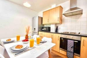 a kitchen with a table with food and orange juice at Next to Headingley Stadium - Perfect for Families & Work - Contact us for Better Offers! in Headingley
