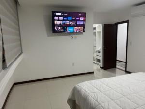 - une chambre avec un lit et une télévision à écran plat dans l'établissement Su estadía perfecta Negocio o Turismo, à Santa Cruz de la Sierra