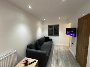 a living room with a couch and a flat screen tv at Newly built one bedroom flat in Kidlington, Oxfordshire in Kidlington