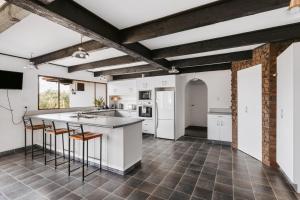 an open kitchen with white cabinets and a counter at Rolleston Motel Thames - Wenzel Motels in Thames