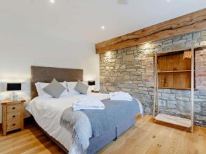 una camera con un grande letto e un muro di pietra di 1 Bed in Taunton 80693 a North Curry