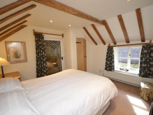 Un dormitorio con una gran cama blanca y una ventana en 2 Bed in Barnstaple LCOBB, en Chittlehampton