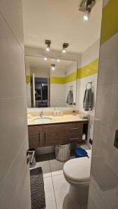 a bathroom with a toilet and a sink and a mirror at Frente a la playa. Vista al mar. in Concón