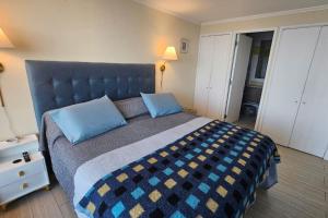 sypialnia z dużym łóżkiem z niebieskimi poduszkami w obiekcie Frente a la playa. Vista al mar. w mieście Concón