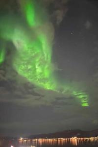 una imagen de la aurora boreal en el cielo en Leilighet med fantastisk utsikt. en Tromsø