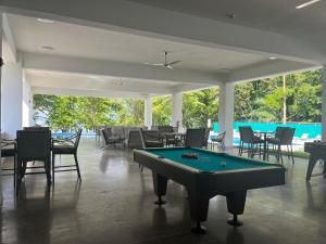 a pool table in a room with tables and chairs at Punta Esmeralda by Punta Leona in Puntarenas
