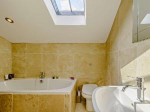 a bathroom with a tub and a toilet and a sink at 2 Bed in Lightcliffe 83521 in Halifax