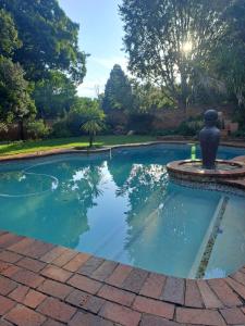 a swimming pool with a fountain in a yard at La Cheteau B&B in Springs