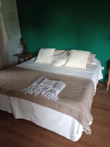 1 dormitorio con 1 cama con pared verde en La Amanda, Estrella federal en Ramallo