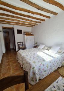 La Posada Amena في Carcabuey: غرفة نوم بسرير وسقف خشبي