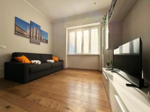 un soggiorno con divano e TV a schermo piatto di Soperga10 a due passi da Stazione Centrale - Milano Real Estate a Milano