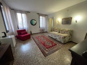 salon z kanapą i czerwonym krzesłem w obiekcie Lions Venice Guest house w Wenecji