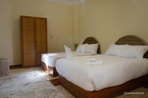 1 dormitorio con 2 camas y toallas blancas. en Golf Pyramids View, en El Cairo