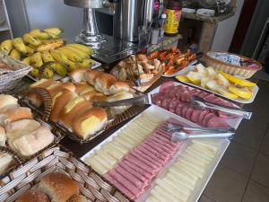 a table with many different types of bread and pastries at Maranata Hotel in Aparecida