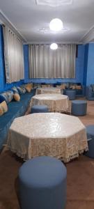 een kamer met vier tafels en blauwe stoelen bij Hôtel Nidaros in Assa