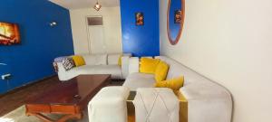 a living room with a white couch and yellow pillows at Delight homestay shared apartment in Nairobi