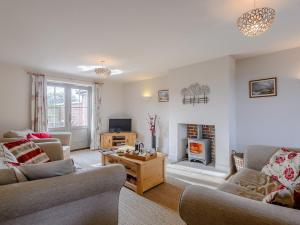 a living room with two couches and a fireplace at 3 Bed in Burnham Deepdale KT045 in Burnham Deepdale