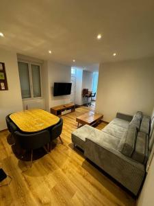 a living room with a couch and a table at Appartement Gîte Le Marmont in Châtillon-sur-Seine