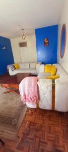 a living room with a white couch and blue walls at Delight homestay shared apartment in Nairobi