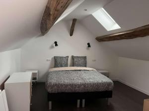 a bedroom with a bed and a white wall at Appartement Gîte Le Marmont in Châtillon-sur-Seine