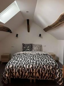 um quarto com um edredão preto e branco numa cama em Appartement Gîte Le Marmont em Châtillon-sur-Seine
