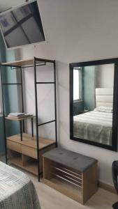 sypialnia z lustrem, łóżkiem i stołem w obiekcie Excelente apto na Lapa w mieście Rio de Janeiro