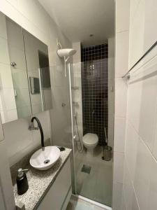 biała łazienka z umywalką i toaletą w obiekcie Excelente apto na Lapa w mieście Rio de Janeiro