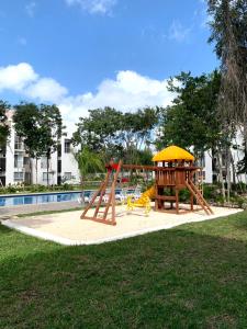 einen Spielplatz in einem Park neben einem Pool in der Unterkunft Departamento 2 habitaciones alberca Luna by Eita in Cancún