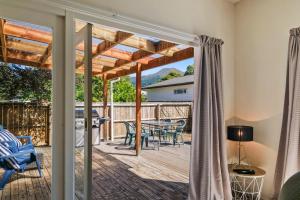 a patio with a table and chairs on a deck at 46 Scarborough Tce in Hanmer Springs