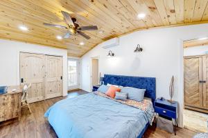 una camera con letto blu e ventilatore a soffitto di Last Lake Lodge a Madawaska