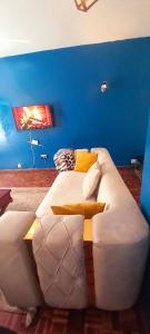a white couch in a room with a blue wall at Delight homestay shared apartment in Nairobi