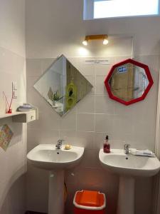 ein Badezimmer mit 2 Waschbecken und einem Spiegel an der Wand in der Unterkunft Solar Das Marés in Fuseta