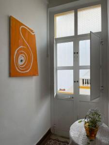 Zimmer mit einem Fenster und einem Tisch mit einer Pflanze in der Unterkunft Solar Das Marés in Fuseta
