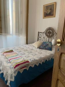 een bed met een deken erop in een slaapkamer bij Solar Das Marés in Fuzeta