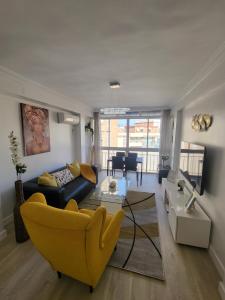 un soggiorno con divano e sedia gialla di Appartement centre ville Malaga a Málaga