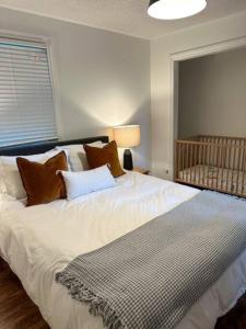 a bedroom with a large white bed with pillows at Waterfront Haliburton, All Season, Fully Equipped Cottage! in Haliburton