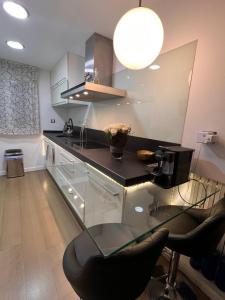 a kitchen with a counter with a glass counter top at Piso en el centro, Lujos a tu alcance, NYC in Zaragoza