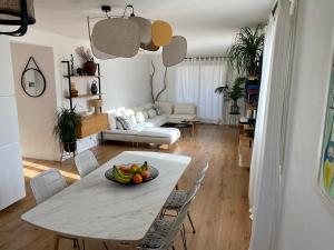 Appartement d'exception, vue Saint-Tropez في سانت تروبيز: غرفة معيشة مع طاولة مع وعاء من الفواكه عليها
