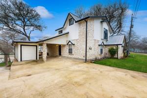 a large white house with a garage at Waterside Haven in New Braunfels
