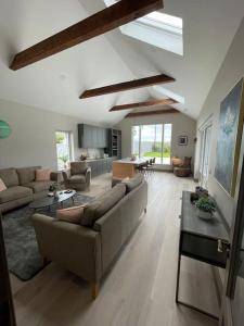 ein Wohnzimmer mit einem Sofa und einem Tisch in der Unterkunft Spanish Point Luxury Home beside sea with Sauna! in Droíchead an Chláir