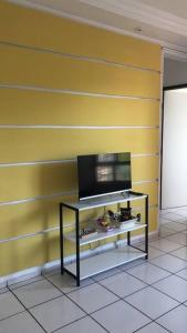 Żółta ściana z telewizorem na półce w obiekcie Apartamento - Salvador BA w mieście Salvador